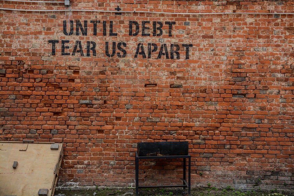 Until debt tear us apart, graffiti on wall.