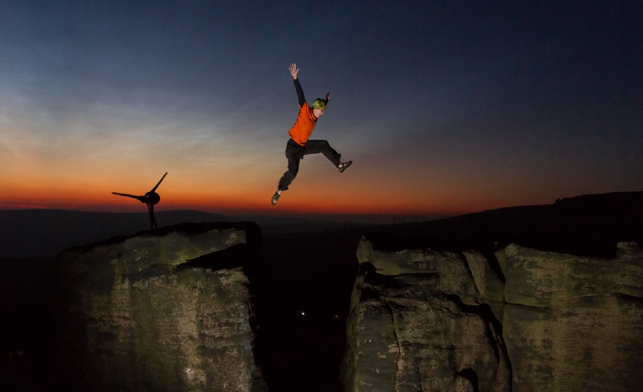 Person leaping over rocks