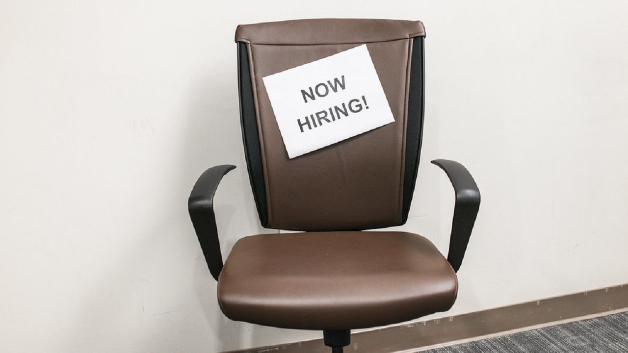 Office chair with 'Now hiring' sign