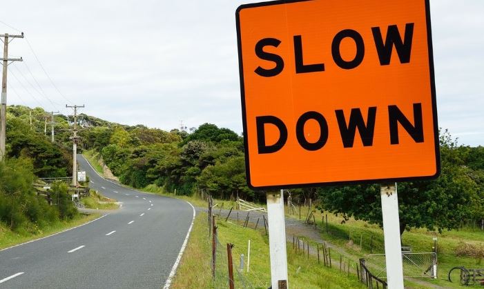 Slow down road sign