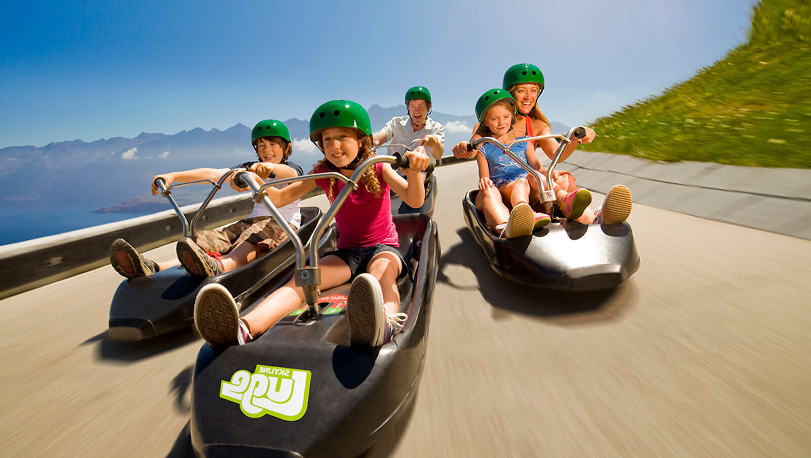 People ride on carts downhill, New Zealand luge company Skyline in Queenstown.