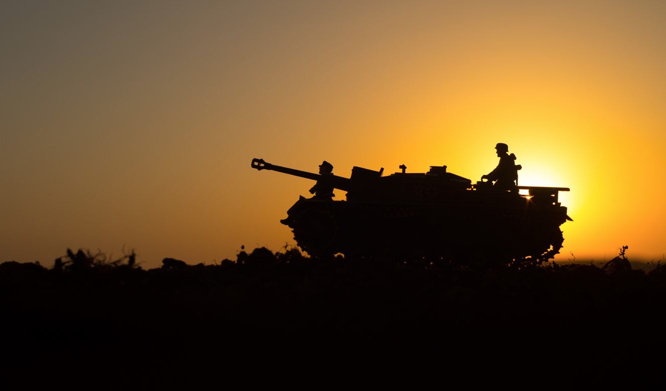 tank in desert at sunset