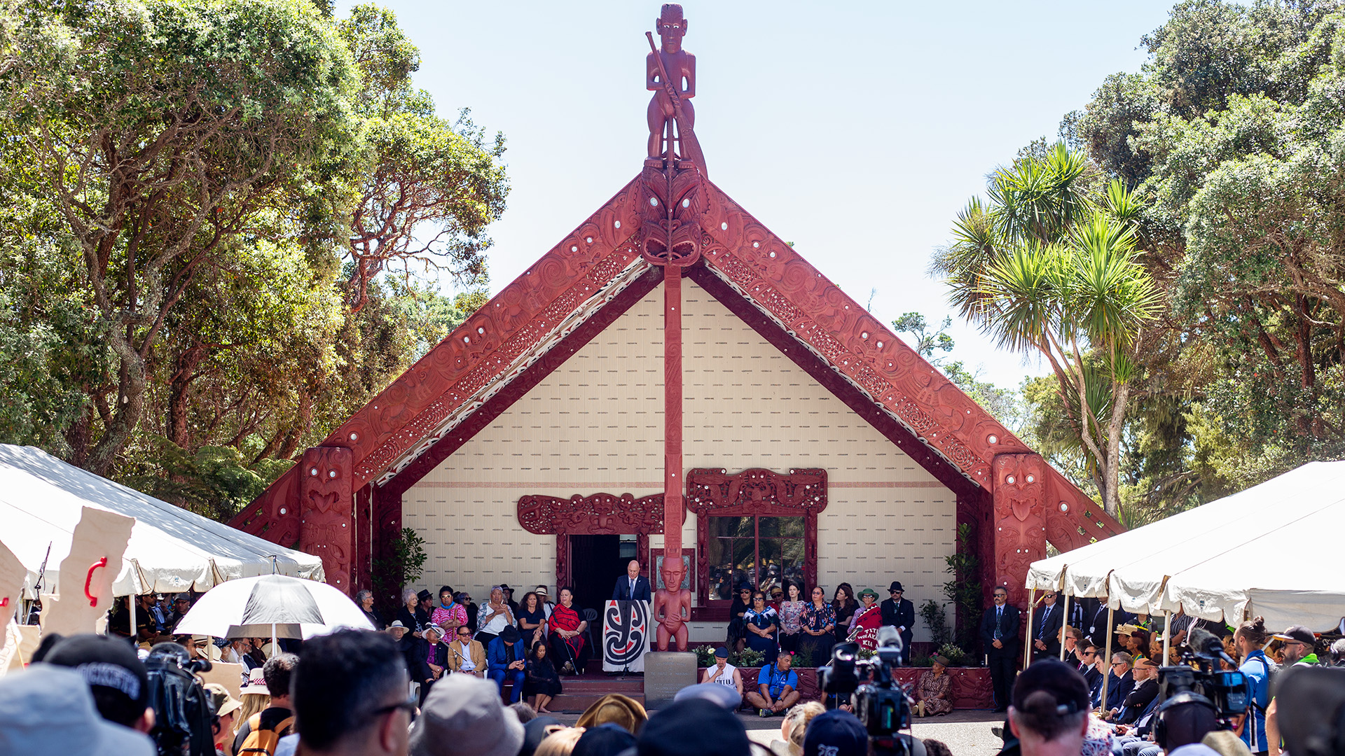 Prime Minister Christopher Luxon speaks from the porch of Te Whare Rūnanga after protesters threatened to drown out his remarks