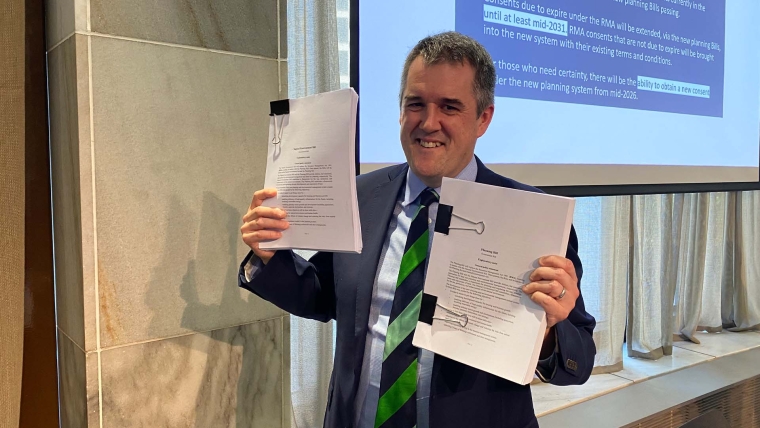 RMA Reform Minister Chris Bishop holding up the Planning Bill and Natural Environment Bill.