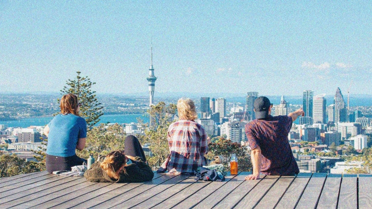 Four people looking out at Auckland City from Mt Eden.
