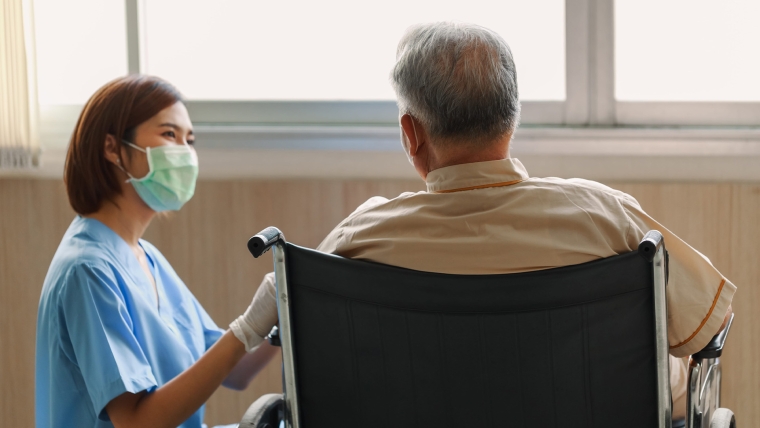 A care worker speaks to an elderly patient. Image source: 123rf.com