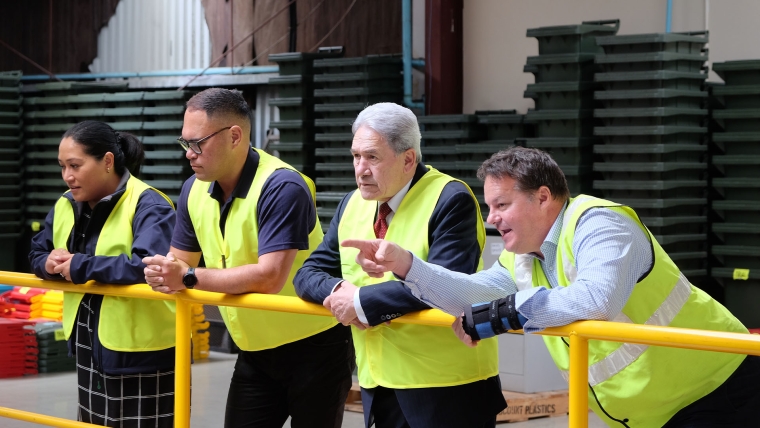 Winston Peters looking at machinery.