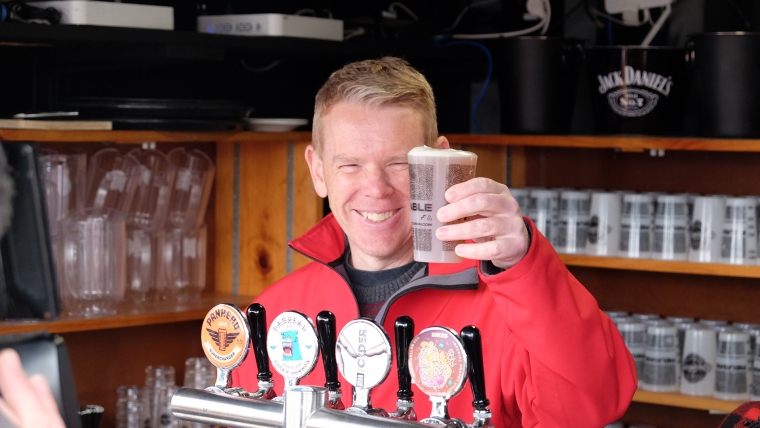 Labour leader Chris Hipkins holds up a pint of beer while on the election campaign trail. Image source: Aaron Masagnay
