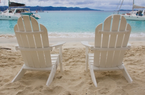 Beach Chairs on shoreline with boats