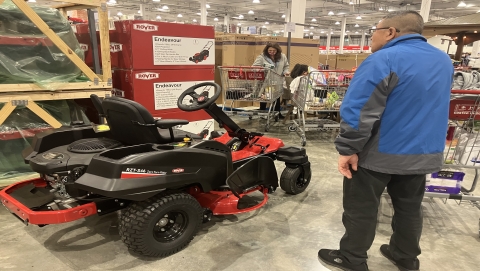Man looks at ride on lawn mower at Costco Auckland.