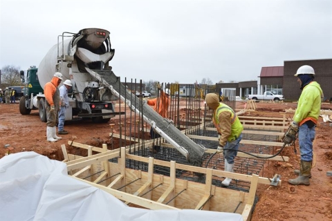 Builders pouring concrete at construction site