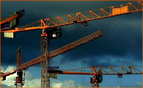 Tower cranes against darkening sky