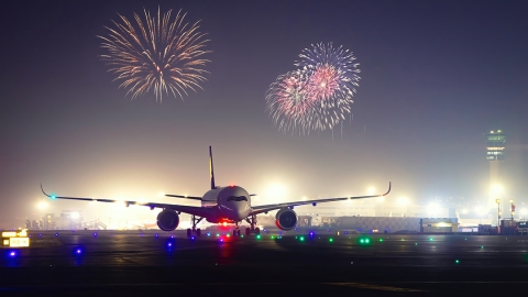 An airplane lands amid fireworks