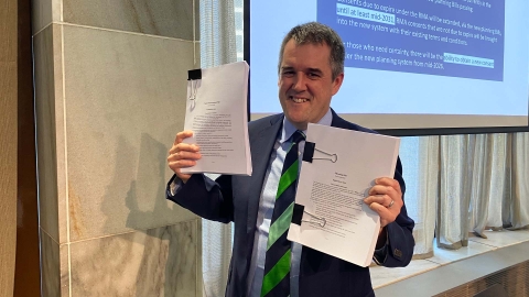 RMA Reform Minister Chris Bishop holding up the Planning Bill and Natural Environment Bill.