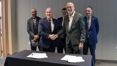 Prime Minister Christopher Luxon and Auckland Mayor Wayne Brown shake hands while Deputy Chair of Ngāti Whātua Ōrākei, Infrastructure Minister Chris Bishop and Auckland Minister Simon Watts smile in the background. 