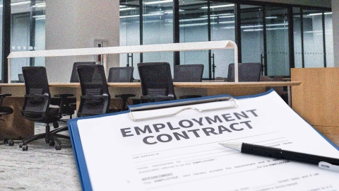 A composite image of an office overlayed with an employment contract.