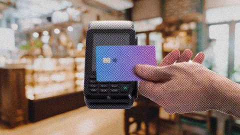 A composite image of a cafe overlayed with a hand holding a card over a payment terminal.