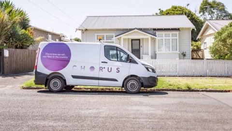 A Chorus van parked on the street outside a home.
