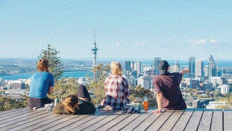 Four people looking out at Auckland City from Mt Eden.