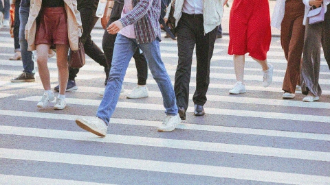 A city crosswalk with people walking.