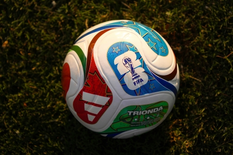 A football sits on a grassy pitch