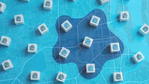 Tiny house-shaped dice scatter across a vibrant blue backdrop overlayed with a detailed map.
