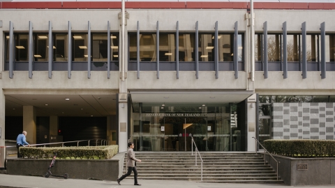 A man in a suit walks past the Reserve Bank of New Zealand in Wellington. 